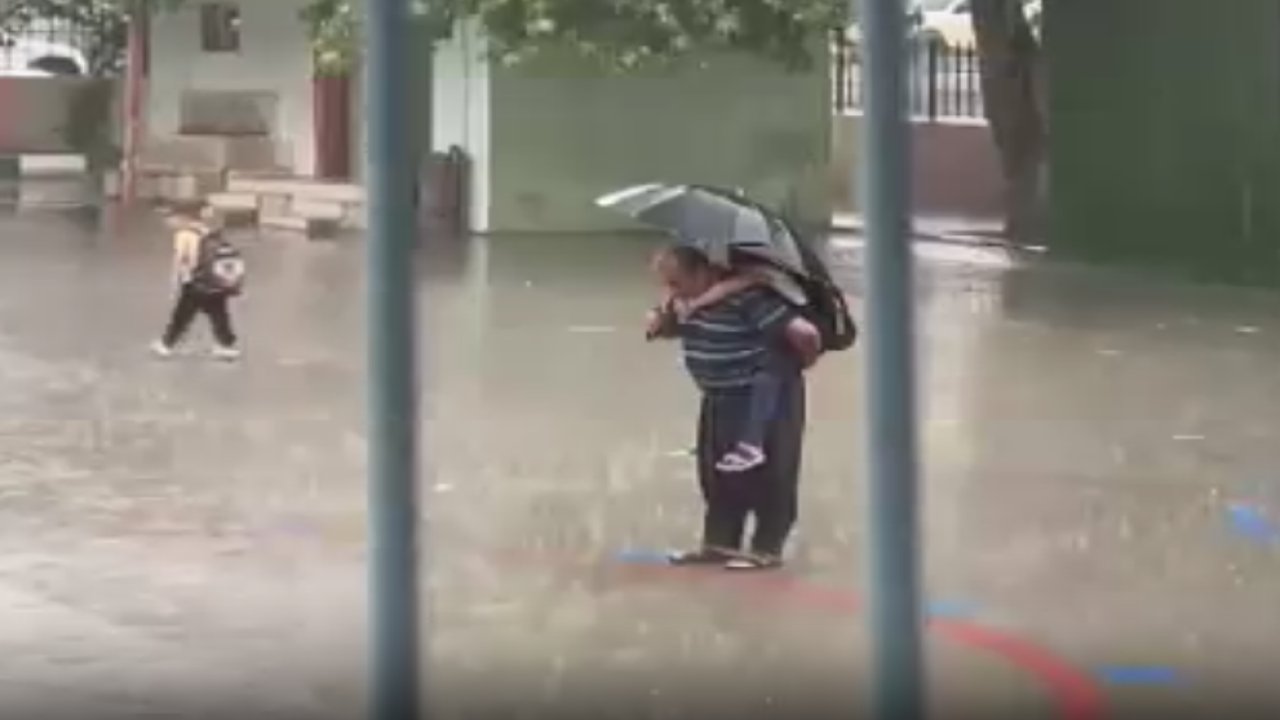 Sırtında torunu, elinde şemsiyesi: İstiklal Marşı'nı yağmur altında böyle dinlediler!