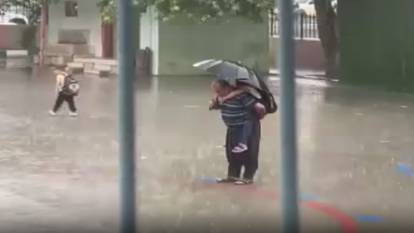 Sırtında torunu, elinde şemsiyesi: İstiklal Marşı'nı yağmur altında böyle dinlediler!